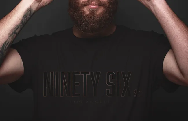 Mockup of a man wearing sunglasses and a Ninety Six branded t-shirt and cap